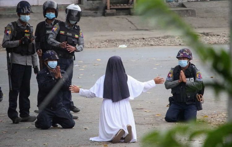 Seorang biarawati memohon kepada para polisi untuk tidak menyakiti pengunjuk rasa di kota Myitkyina, negara bagian Kachin, Myanmar, 8 Maret 2021, saat demonstrasi menentang kudeta militer. FOTO: AFP