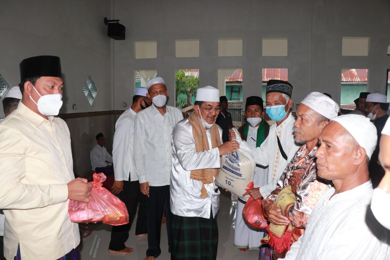 Bupati Tanjung Jabung Barat, Anwar Sadat membagikan bantuan kepada masyarakat di Dusun Mudo, Muara Papalik, Jumat (26/3). FOTO: Dokumen istimewa